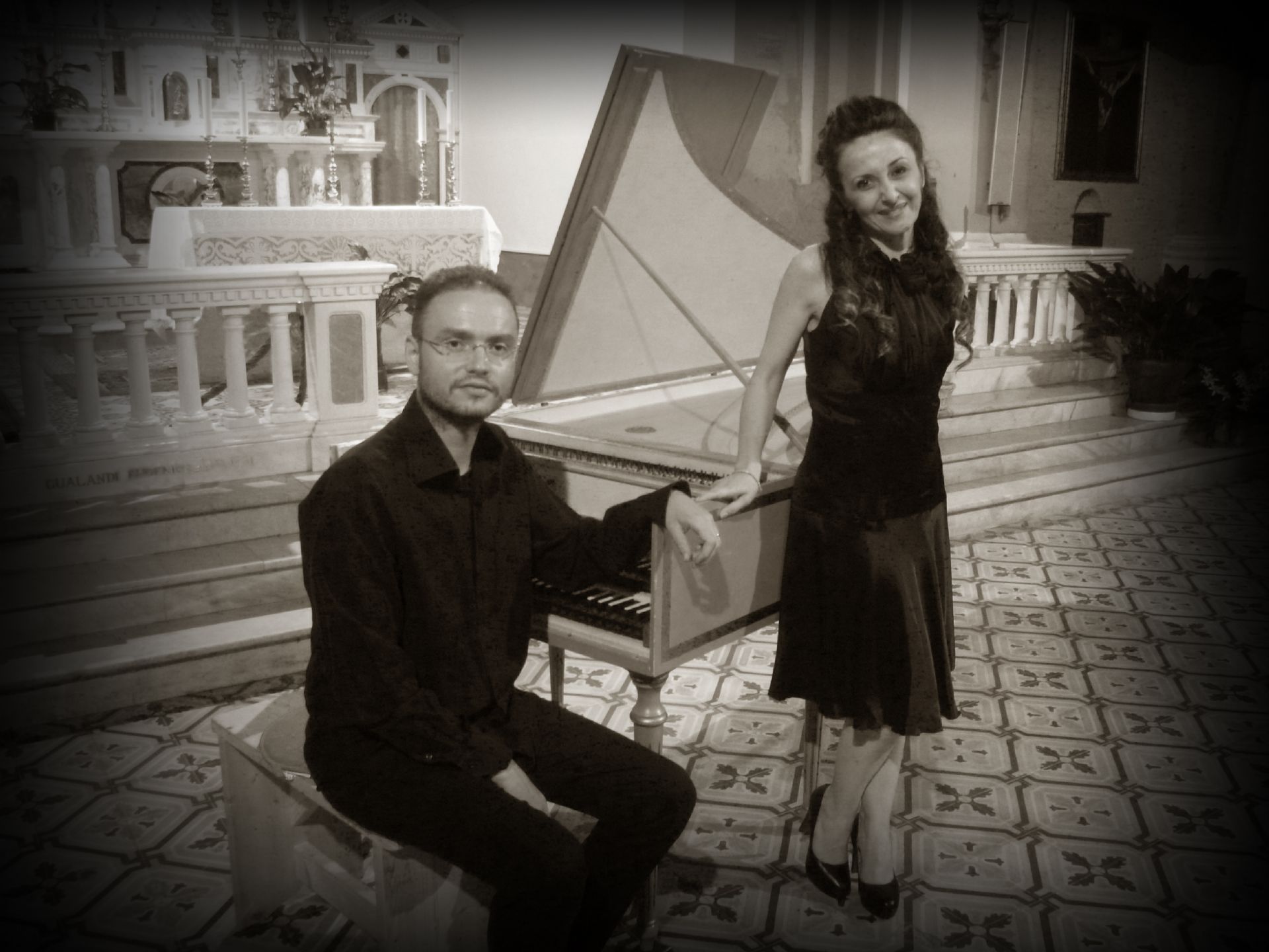 soprano Paola Matarrese in piedi appoggiata al piano al quale siede il M° Enrico Bernardi