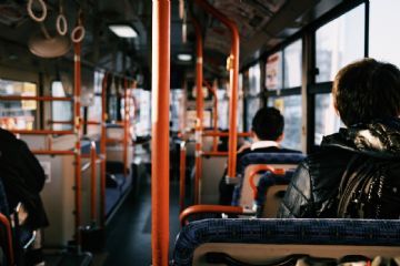 Interno autobus con qualche persona seduta vicino alla finestra