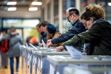 L'immagine evidenza gli scrutatori in un contesto di referendum.