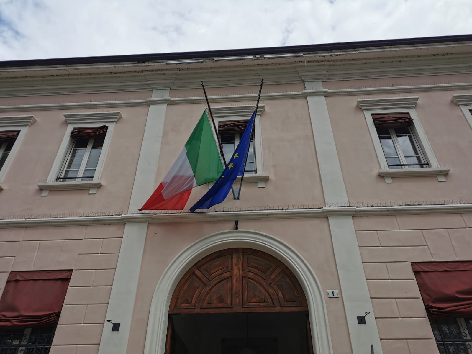 Fotografia Comune di Castenaso con le bandiere italiana ed europea a mezz'asta.